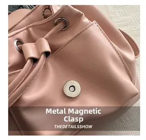 Detail of pink ballet-style backpack featuring a magnetic metal clasp and drawstring