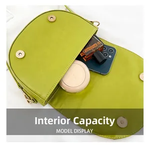 Interior capacity of the green saddle bag showing phone and cosmetics space