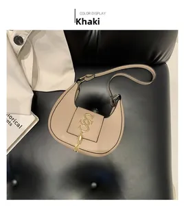 Close-up of khaki leather hobo bag with gold metal buckle and fringe tassel detail