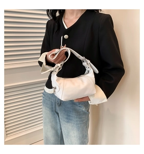 Detail of white PU leather bag featuring a zipper pocket and silver metal buckle hardware