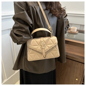 Detail of beige quilted handbag showing triangular stitching and matte leather texture