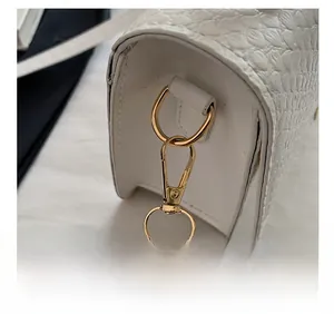 Detailed macro view of white crocodile pattern leather with premium golden metal hardware