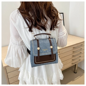 Model showing a contrast color backpack with gold studs and faux leather straps