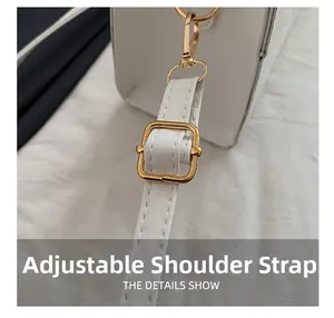 Detail showing adjustable white faux leather strap with golden buckle and stitching