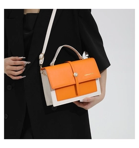 Détail du sac à main bicolore orange et beige avec boucle en métal et bandoulière fine