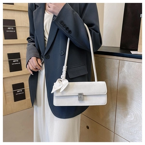 White leather shoulder bag with crystal buckle and silk scarf detail on female model