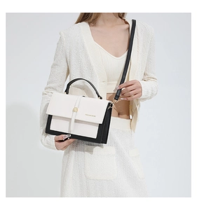 Détail d'un sac à main chic bicolore noir et blanc avec ferrures dorées et bandoulière