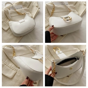 Detail view showing white crescent shoulder bag texture, gold hardware, and interior layout