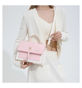 Détail du sac bandoulière rose et blanc avec texte de mode et boucle en métal