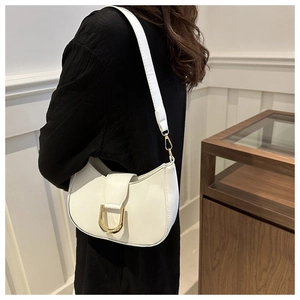 Detailed view of white hobo bag with large gold U-buckle worn on model shoulder