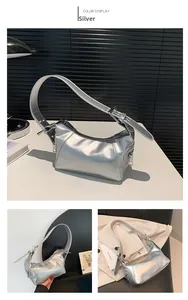 Detail of silver metallic baguette bag showing wide shoulder strap and modern textures