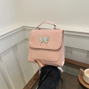 Sac à dos en cuir plissé rose avec ornement papillon argenté et poignée de transport chic