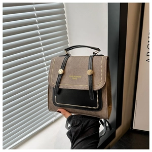 Detail of vintage flap backpack with matte tan texture and gold rivet trim accents