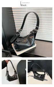 Detail of black PU leather underarm bag with adjustable buckle strap and silver hardware