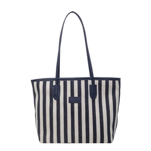 Large striped canvas tote bag with navy blue leather handles and minimalist design
