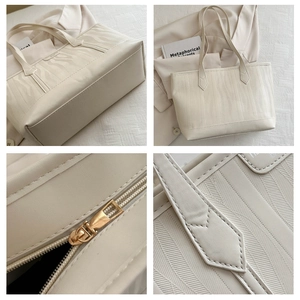 Detailed view of beige tote bag texture with vertical embossing and gold zipper hardware