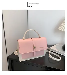 Detail of pink and beige crossbody bag with golden ring buckle on a wooden cabinet