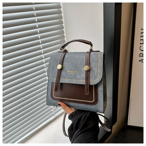 Detail of grey-blue retro backpack with gold rivets and leather trim stitching