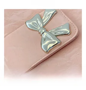 Nahaufnahme der rosa strukturierten Handtasche mit einer silbernen Metallschleife