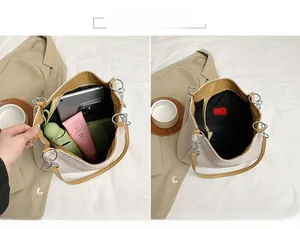 Detail view of large woven tote bag interior with brown leather strap and main compartment