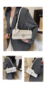 Close-up of white suede baguette bag featuring a silver crystal buckle and silk scarf detail