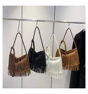 Detail of bohemian fringe shoulder bags in four colors with braided strap accents
