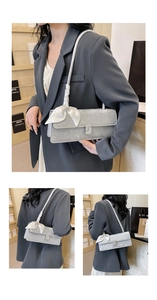 Close-up of light grey baguette bag featuring a decorative silk scarf and crystal buckle