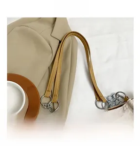 Detail of adjustable faux leather shoulder strap with silver metal rings and chain