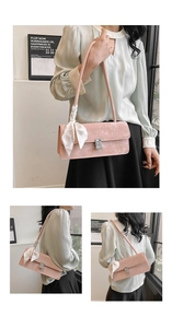 Detail of pink faux suede shoulder bag with rhinestone buckle and floral silk scarf accessory