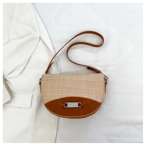 Detail einer Satteltasche aus gewebtem Stroh mit braunem Leder und Metallschnalle