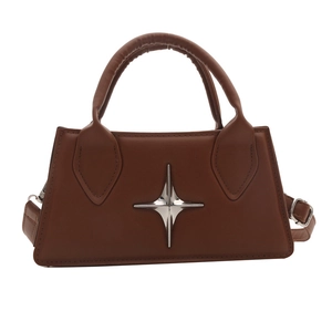 Brown leather crossbody bag with silver star emblem and sturdy top handle on white background