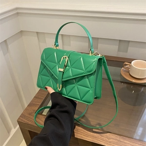 Green quilted faux leather handbag with gold buckle and adjustable crossbody strap