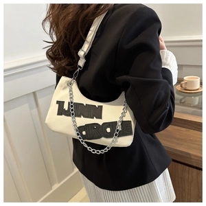 Detail of white denim crescent bag with chain strap and 1JNN CIRCLE lettering