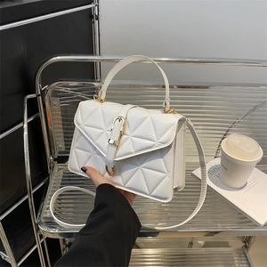 White quilted shoulder bag with triangle lattice texture and golden lock in hand