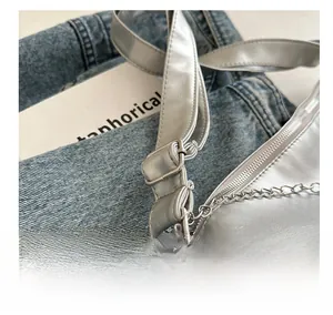 Close-up of adjustable metal buckle and chain on silver commuter shoulder bag