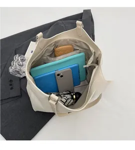Interior view of large cream tote bag showing compartments for tablet and essentials