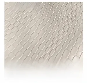 Macro shot of white crocodile embossed texture and golden metal tag on the shoulder bag