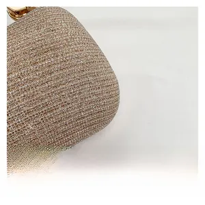 Dettaglio del tessuto intrecciato glitter champagne e della chiusura metallica della borsa