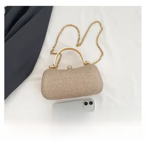 Borsa da sera champagne dorata con manico in metallo e confronto dimensioni con telefono