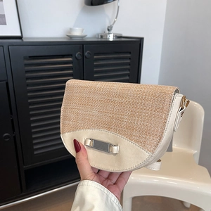 Kontrastreiche Stroh-Patchwork Satteltasche mit Metallschnalle im modernen Wohnambiente