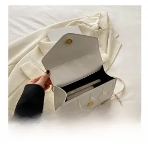 Detail showing internal capacity of the off-white quilted chain bag with a mobile phone