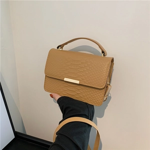 Minimalist khaki embossed leather crossbody bag with top handle and gold clasp hardware