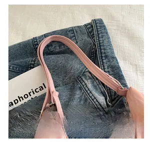Detailed close-up of pink leather handle and silver metal buckle on a fashion tote bag