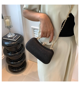 Dettaglio pochette da sera nera glitterata con catena dorata e chiusura in cristallo lussuosa