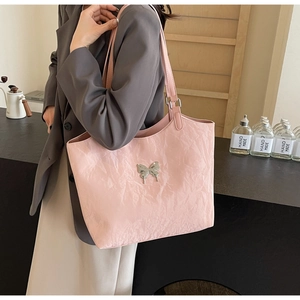Detailed texture of pink velvet tote bag featuring a silver butterfly metallic ornament