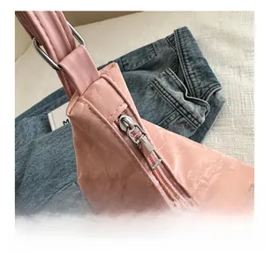 Close-up of pink textured backpack with smooth silver zipper and metal buckle detail