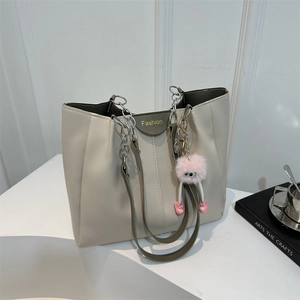 Elegante borsa tote crema con tracolle verde oliva e logo Fashion in un ambiente moderno