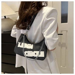 Detail of black half-moon shoulder bag with white LINN CIRCLE text and silver chain