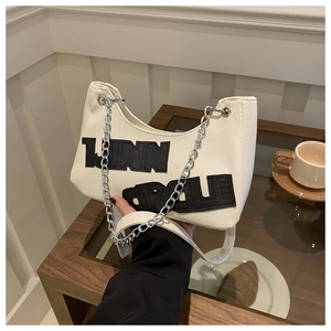 Detailed close-up of white leather shoulder bag with LINN CIRCLE embroidery and chain