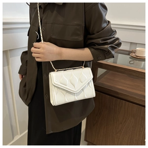 Close-up of white quilted water-drop pattern crossbody bag with gold chain strap